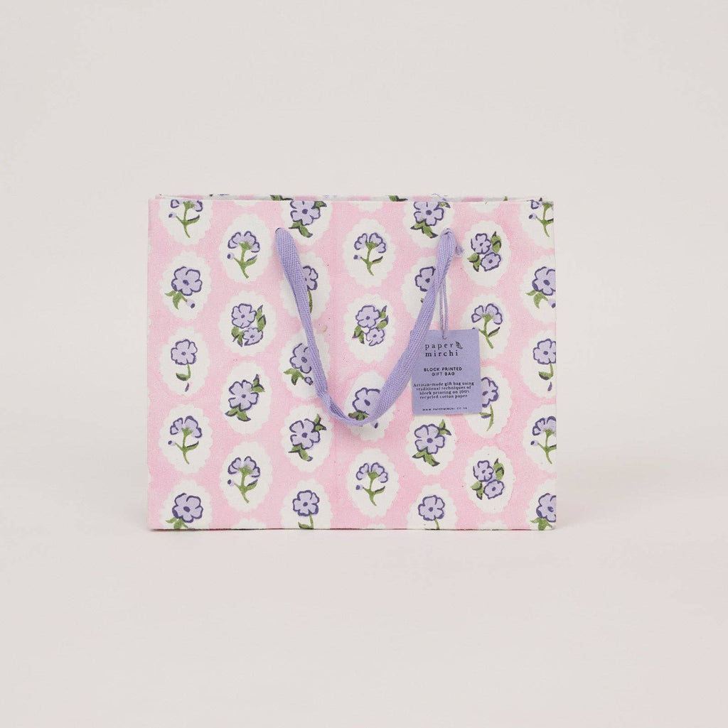 Floral-patterned tote bag with a visible brand label on a light gray background
