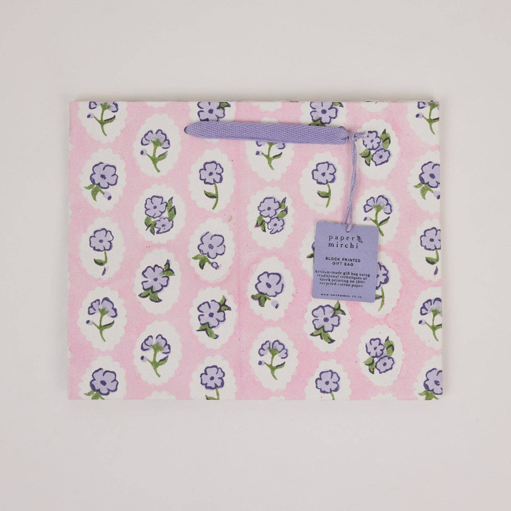 Floral-patterned product on a pink background with a visible brand label.