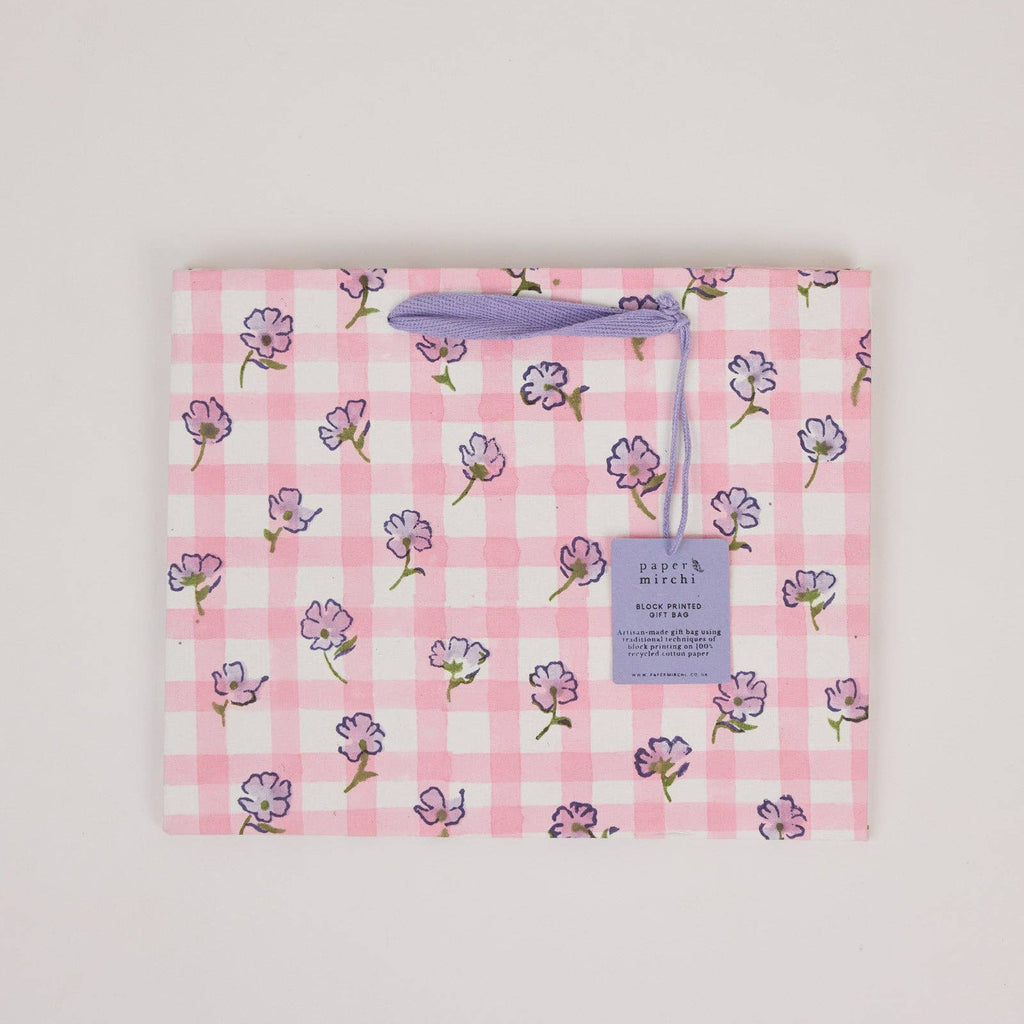Floral-patterned product packaging with a visible brand tag on a light gray background