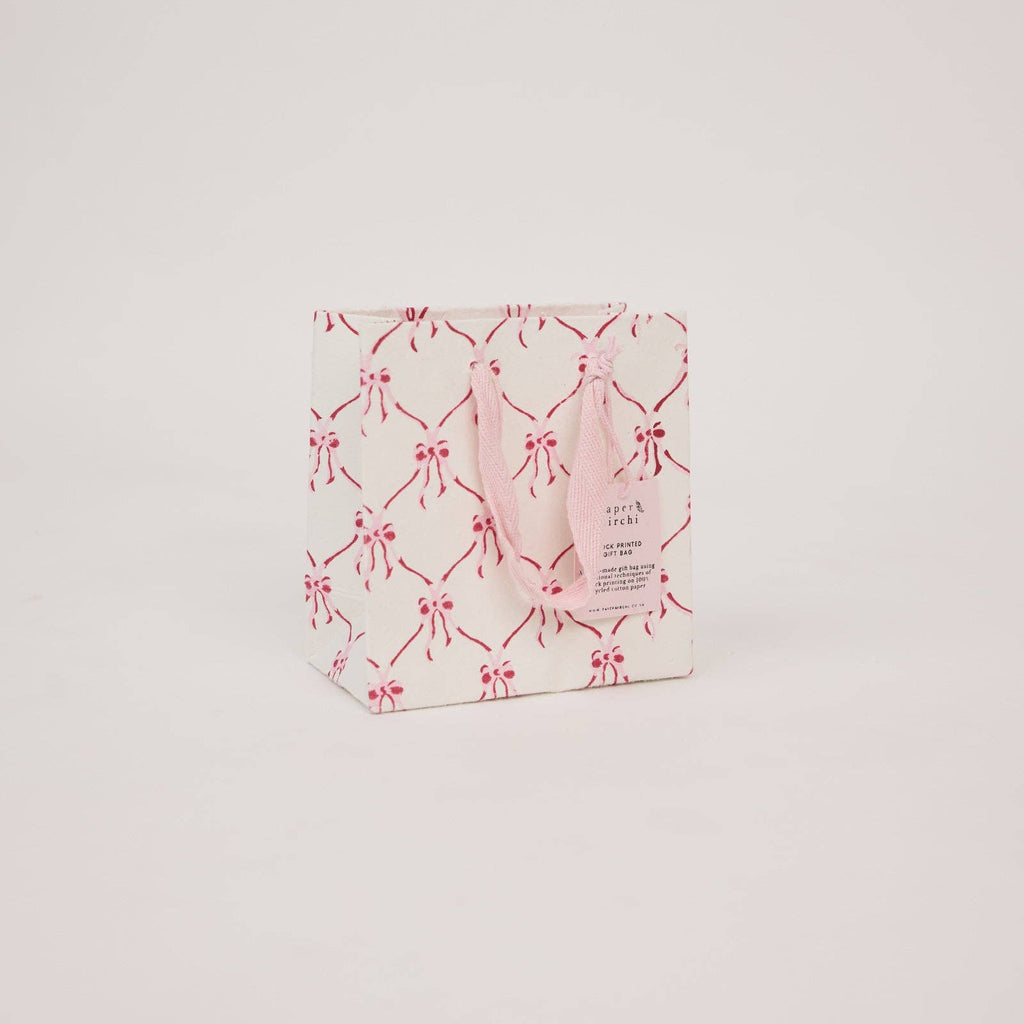 Packaged product with pink bows on a light gray background