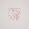 Packaged product with pink bow pattern on a light gray background