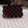 Dark chocolate truffles with a red pattern on a white and red patterned surface.