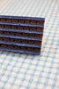 Rectangular chocolate bar with a textured surface on a blue and white checkered fabric background