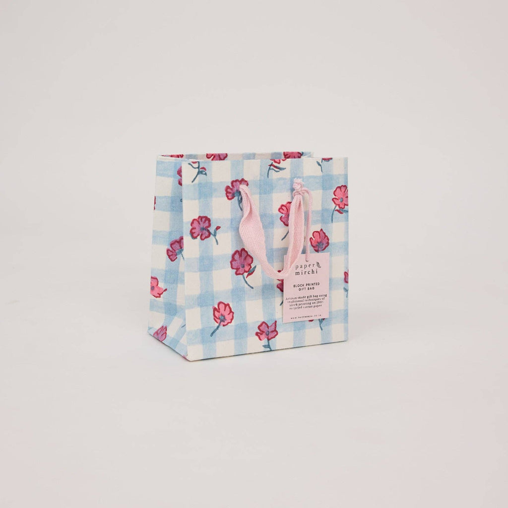 Small gift bag with floral and checkered pattern on a light gray background