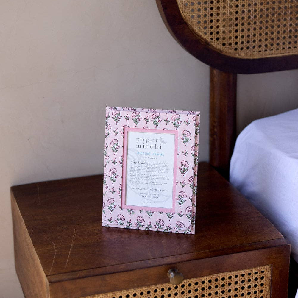Decorative sign on a wooden nightstand with a wicker headboard in the background
