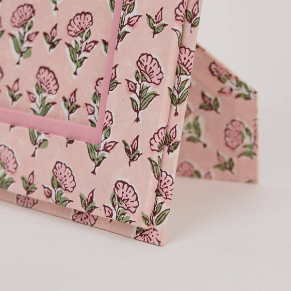 Floral-patterned pink paper on a white background