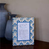 Decorative picture frame with intricate blue and white design on a wooden surface.