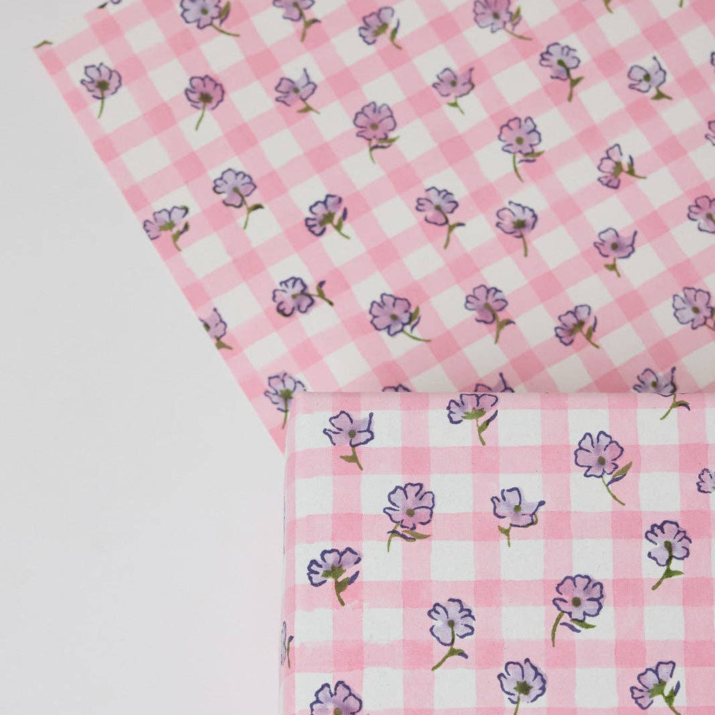 Two pink checkered fabrics with floral patterns on a white background