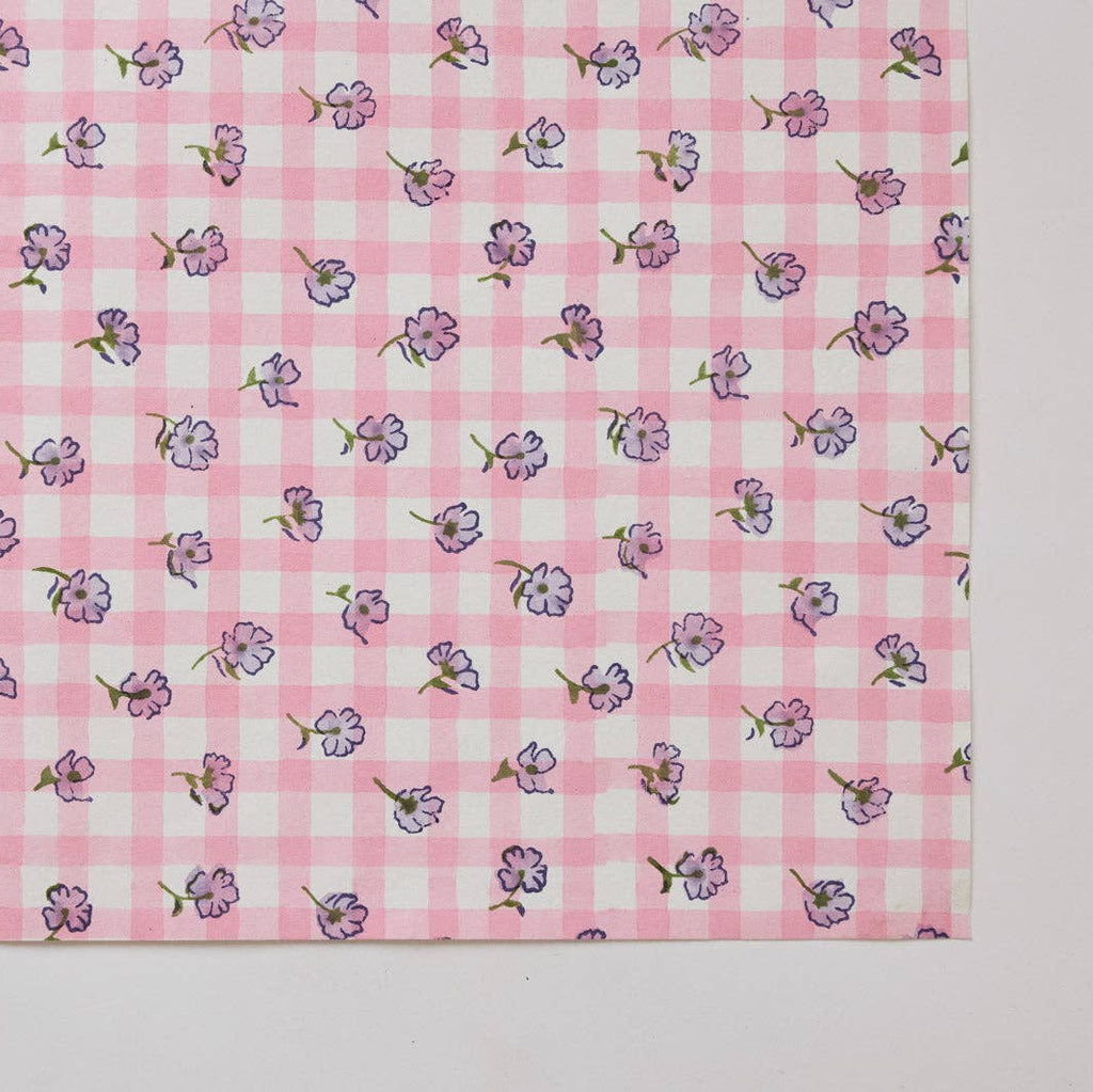 Pink checkered fabric with small floral patterns on a white background