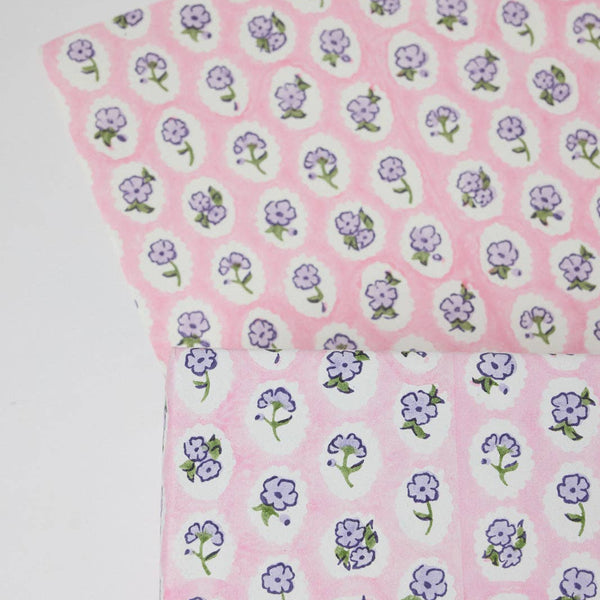 Fabric with purple floral pattern on pink background