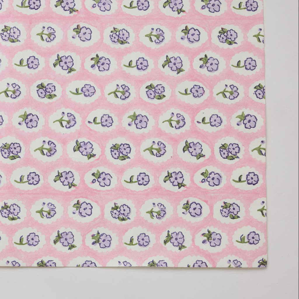 Fabric with small floral pattern on a pink background