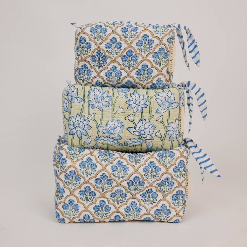 Stack of fabric rolls with floral patterns on a light gray background
