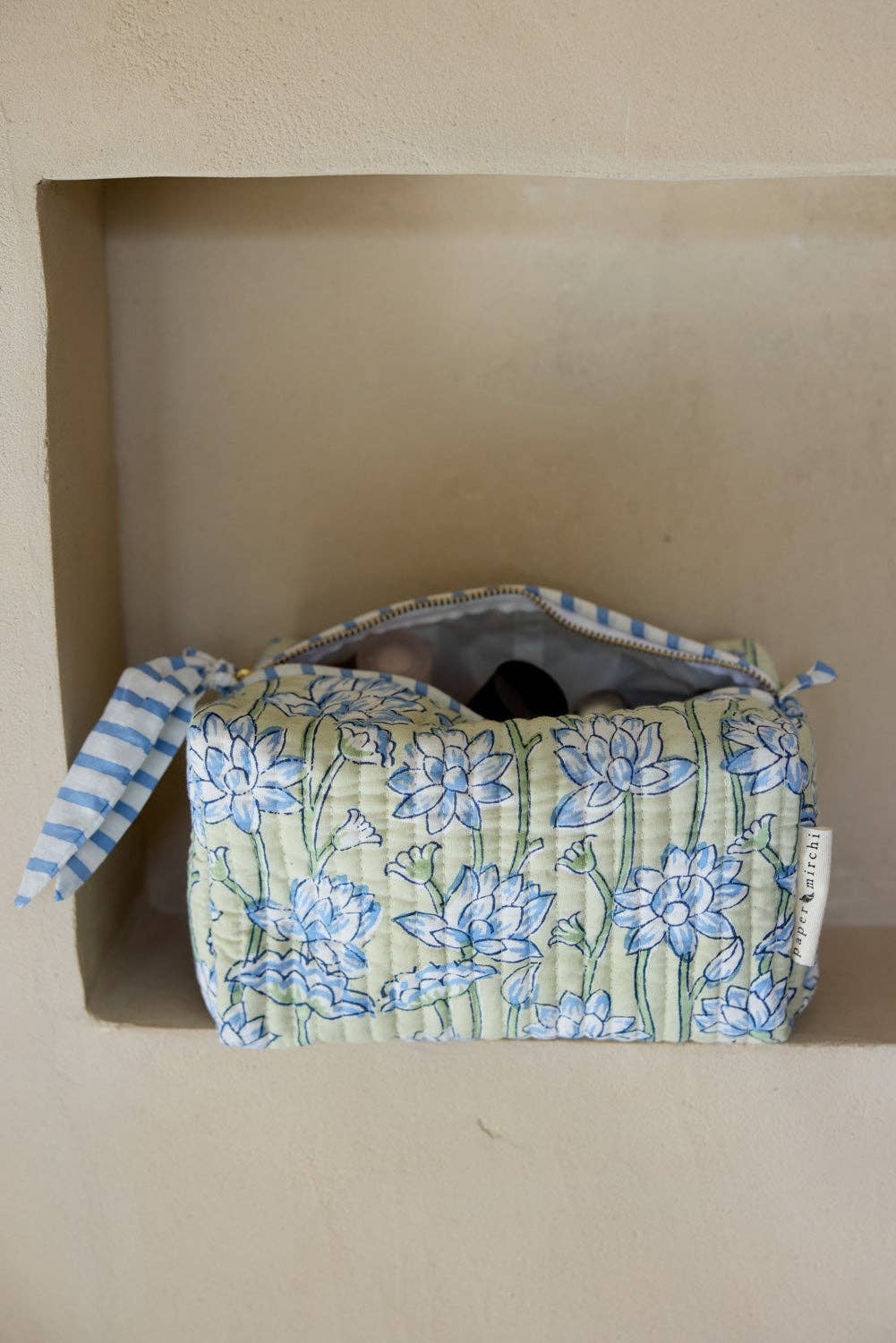 Floral-patterned fabric roll with blue and white stripes on a beige background