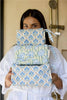 Woman holding three floral-patterned bags in a bathroom setting