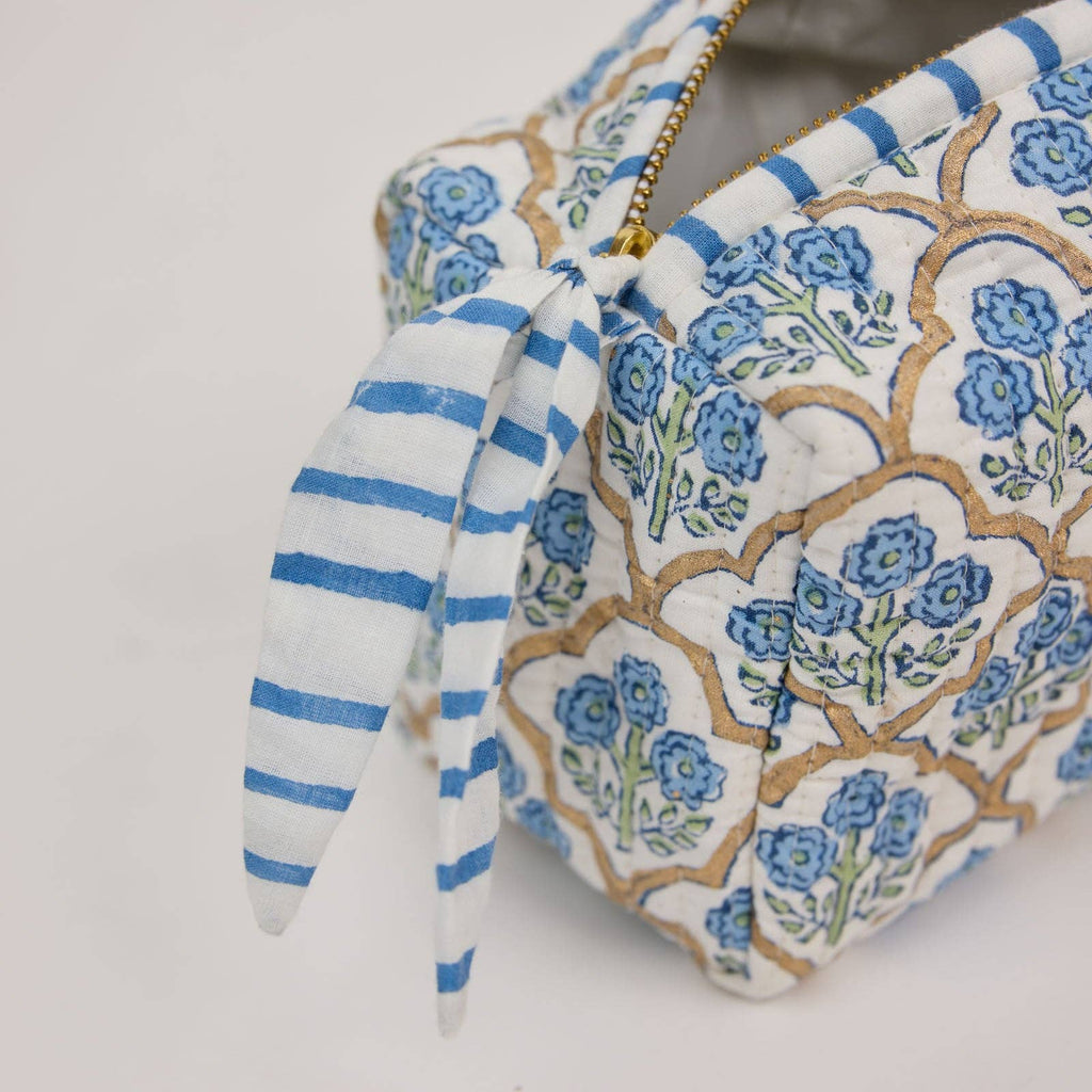Floral patterned pouch with a blue and white striped bow on a light gray background