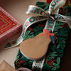 Gift wrapped in festive paper with a decorative ribbon and tag.