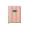 Notebook with pink and white striped cover and green label on a white background