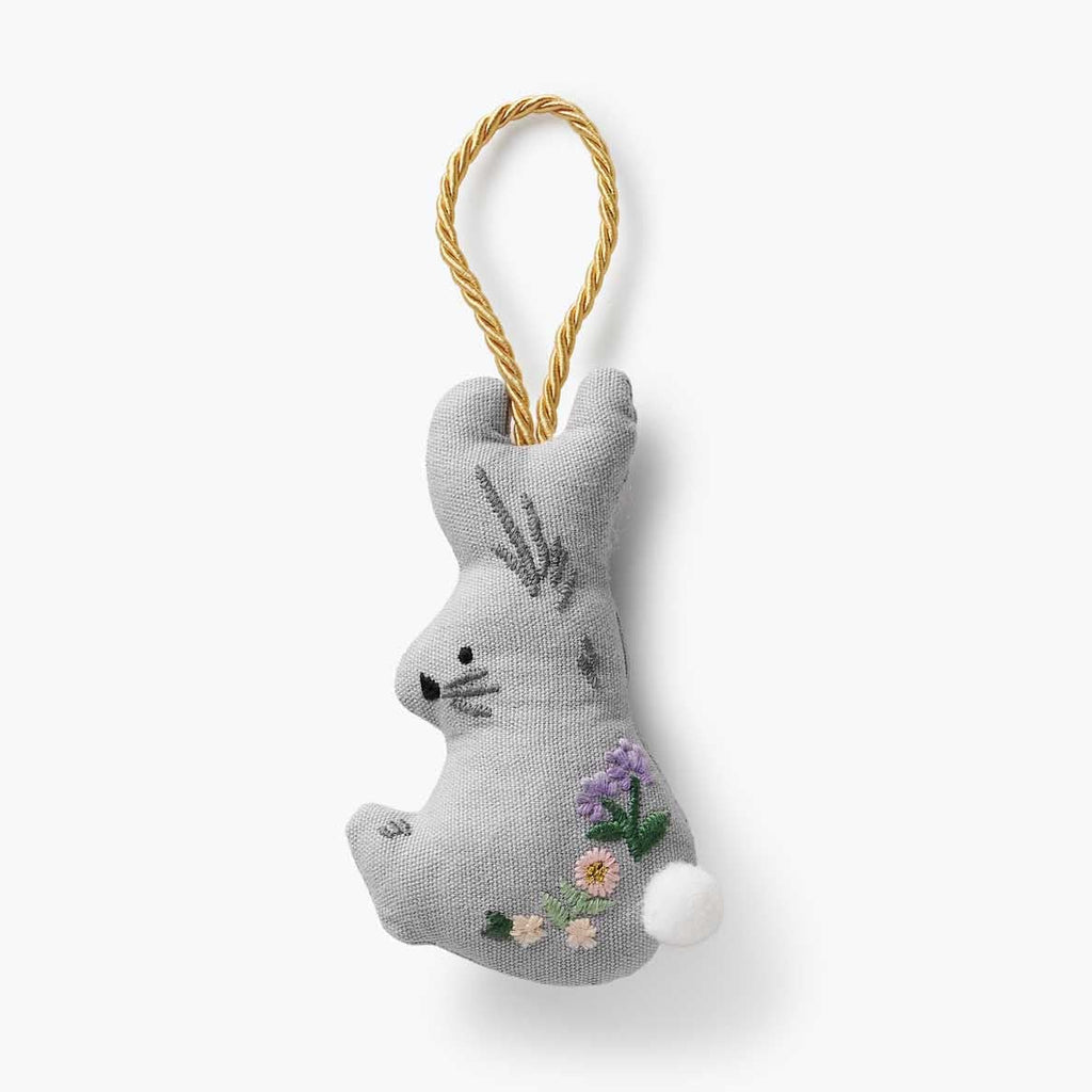 Gray cat-shaped plush toy with floral details on a white background