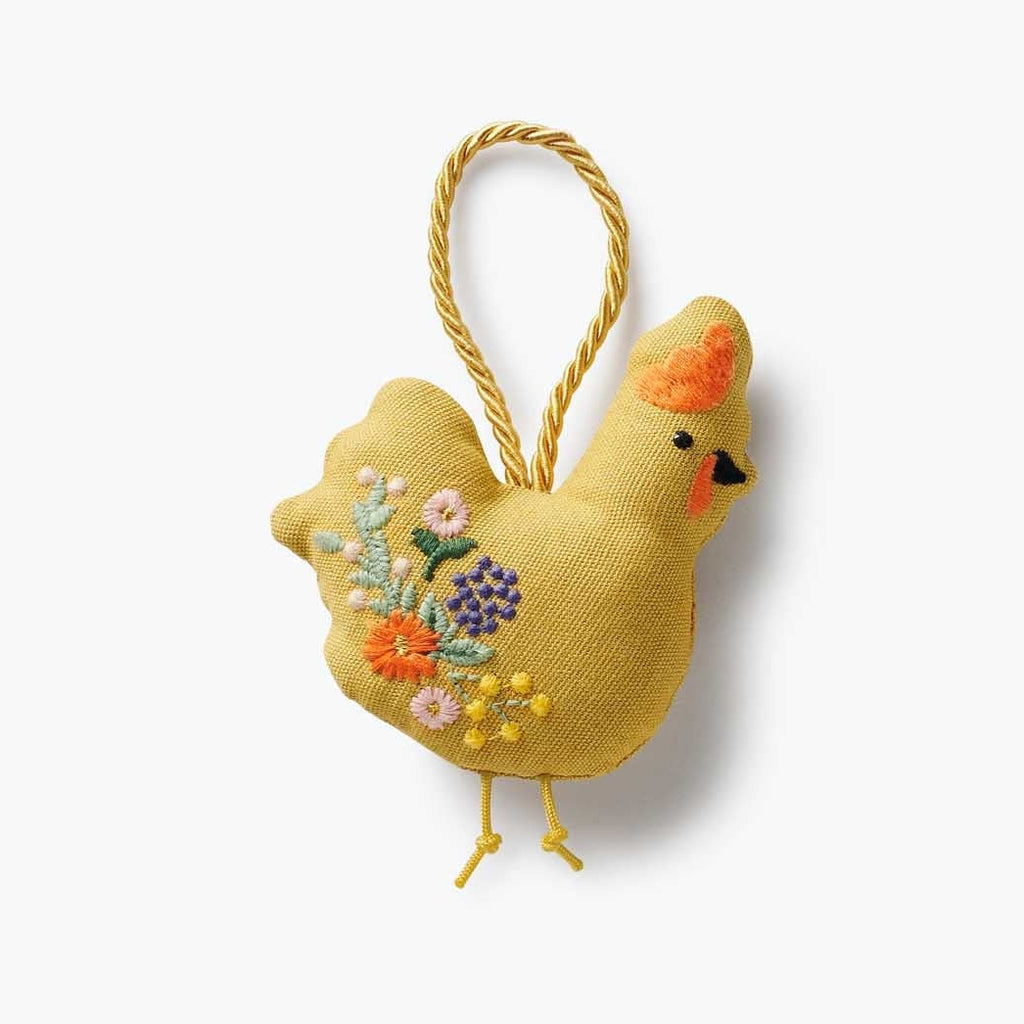 Yellow embroidered chicken ornament with floral details on a white background