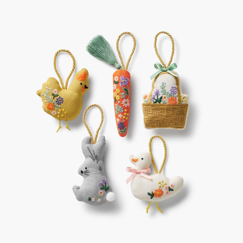Set of decorative Easter ornaments including a chick, carrot, basket, bunny, and chick on a white background.