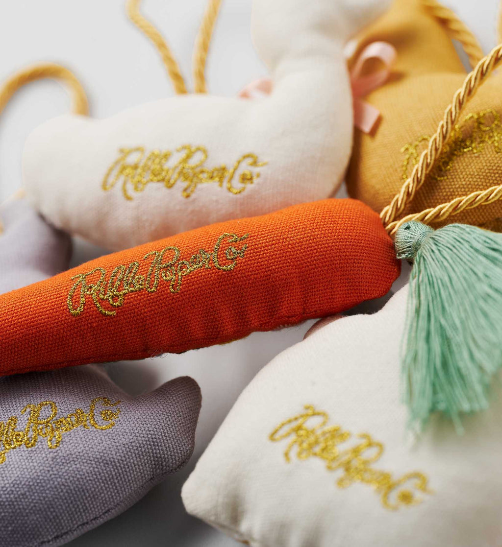 Decorative pillows with 'Ruffle Rogue Co.' embroidery on a light background