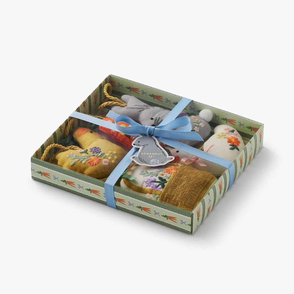 Set of decorative items in a box with a blue ribbon on a white background