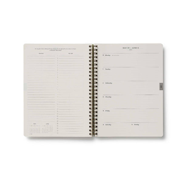Spiral-bound planner with a grid layout on a white background