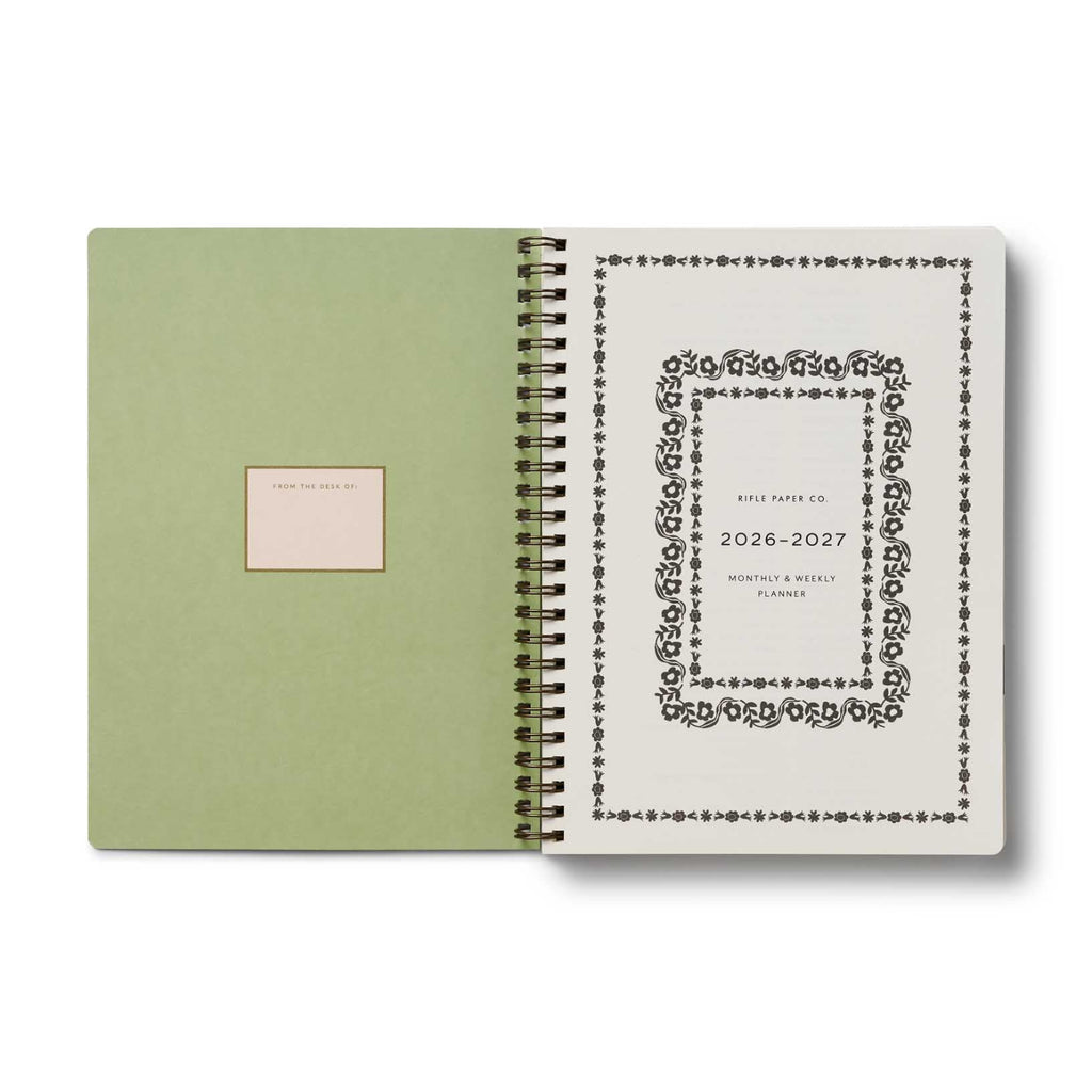 Green planner with a decorative cover and white interior on a white background
