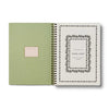 Green planner with a decorative cover and white interior on a white background