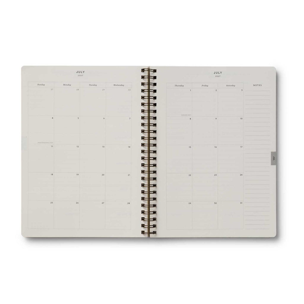 Open spiral-bound planner with grid and dot matrix pages on a white background