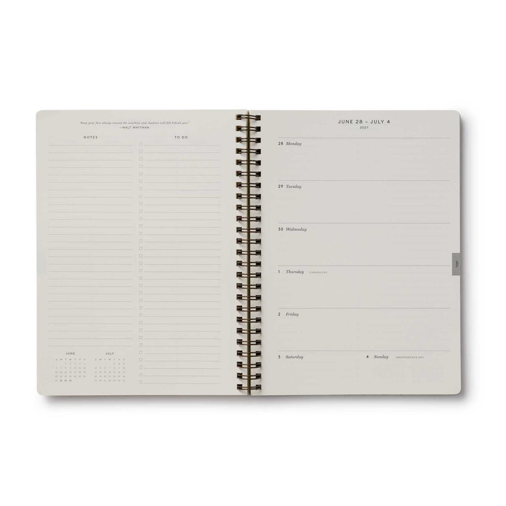 Open spiral-bound planner with daily schedule on a white background