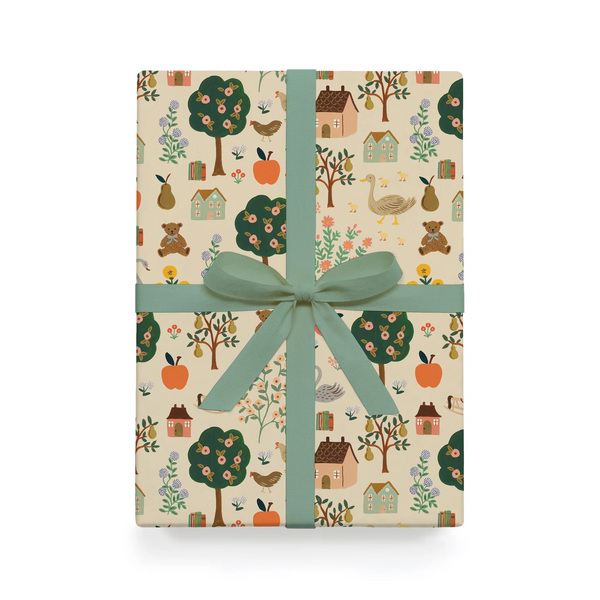 Gift box with nature-themed design and green ribbon on a white background