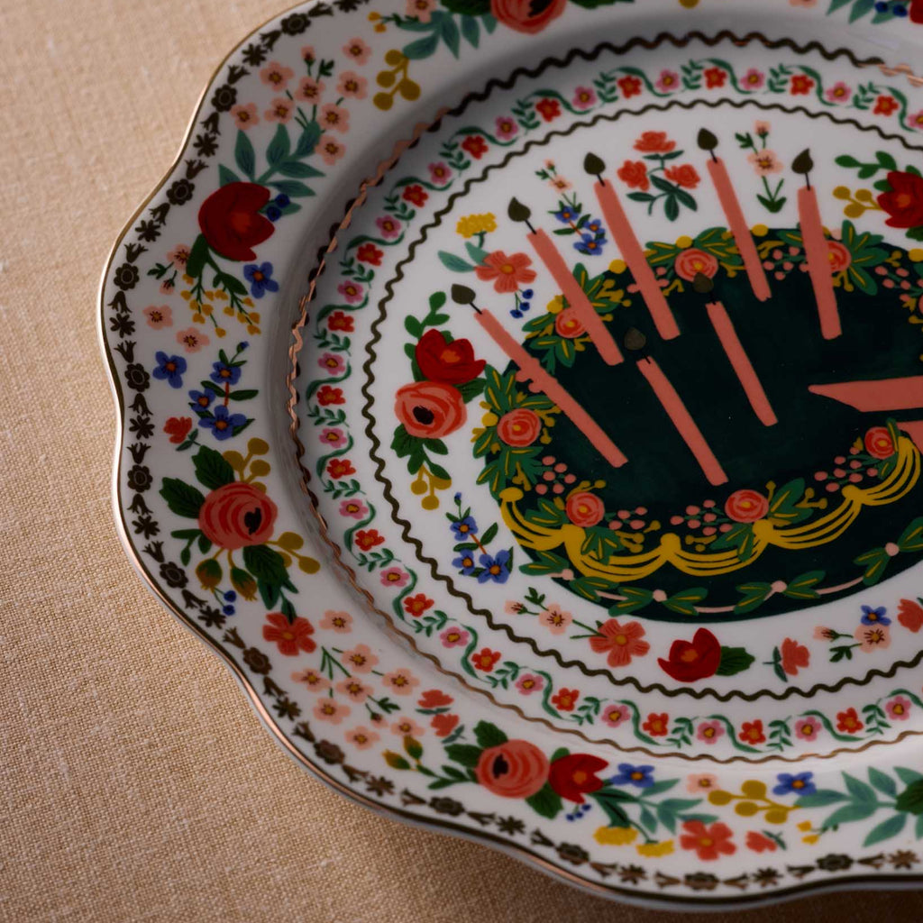 Decorative plate with floral and candle design on a beige surface