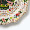 Decorative plate with floral patterns and a person holding a cake on a white background