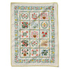 Embroidered quilt with floral and botanical patterns on a white background