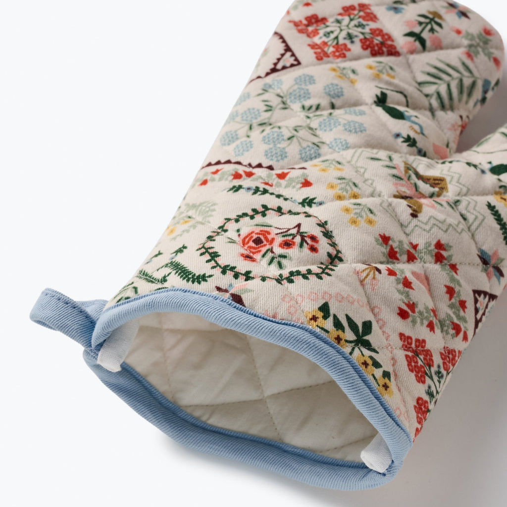 Pair of floral-patterned oven mitts on a white background