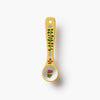 Decorative yellow spoon with floral patterns on a white background