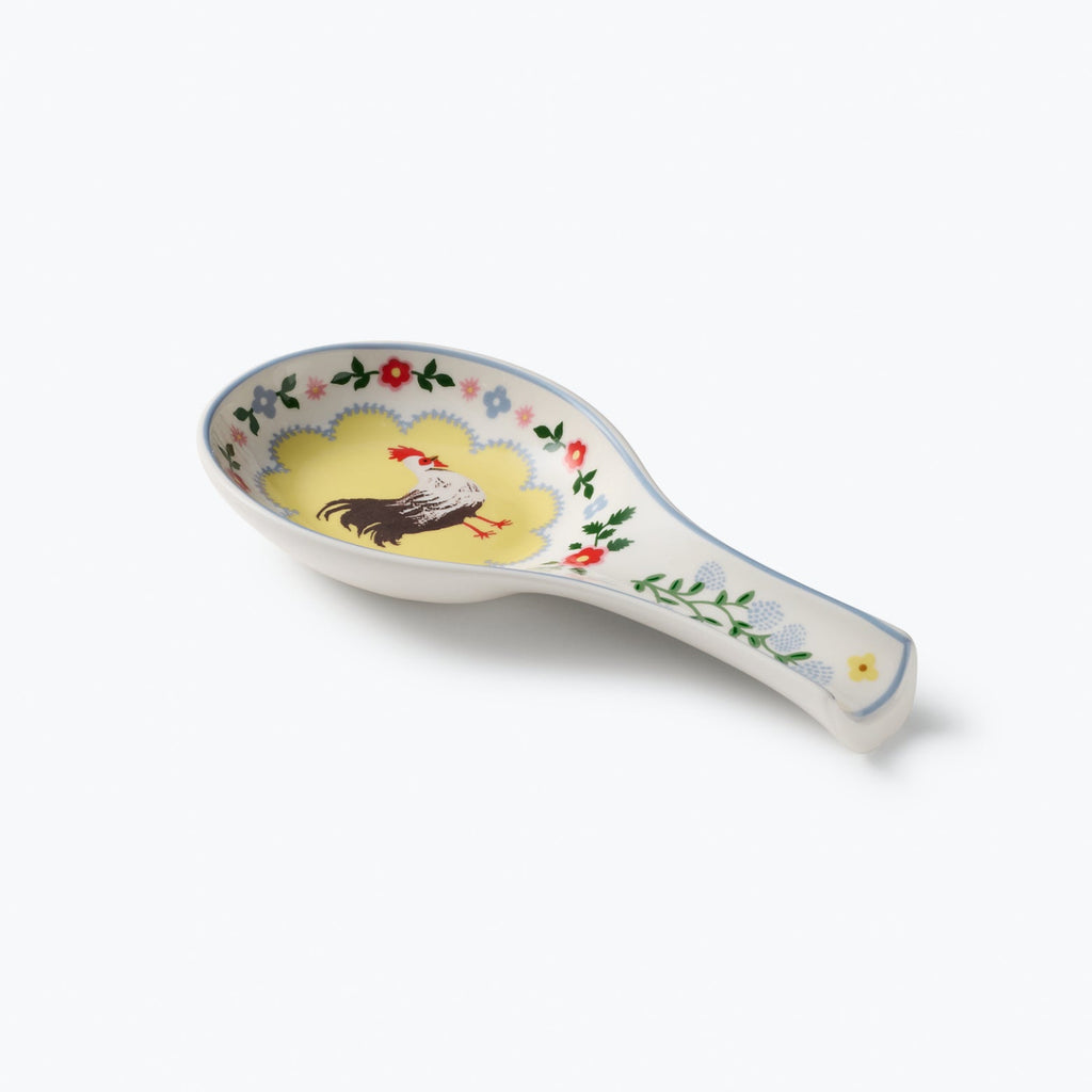 Decorative ceramic spoon rest with rooster design on a white background