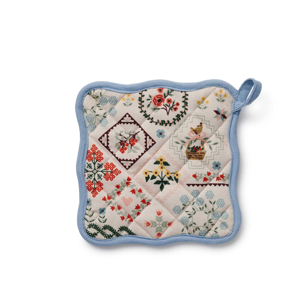 Quilted pot holder with floral and geometric patterns on a white background