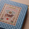 Cookbook with a checkered cover featuring a cow illustration and 'Recipes' text.