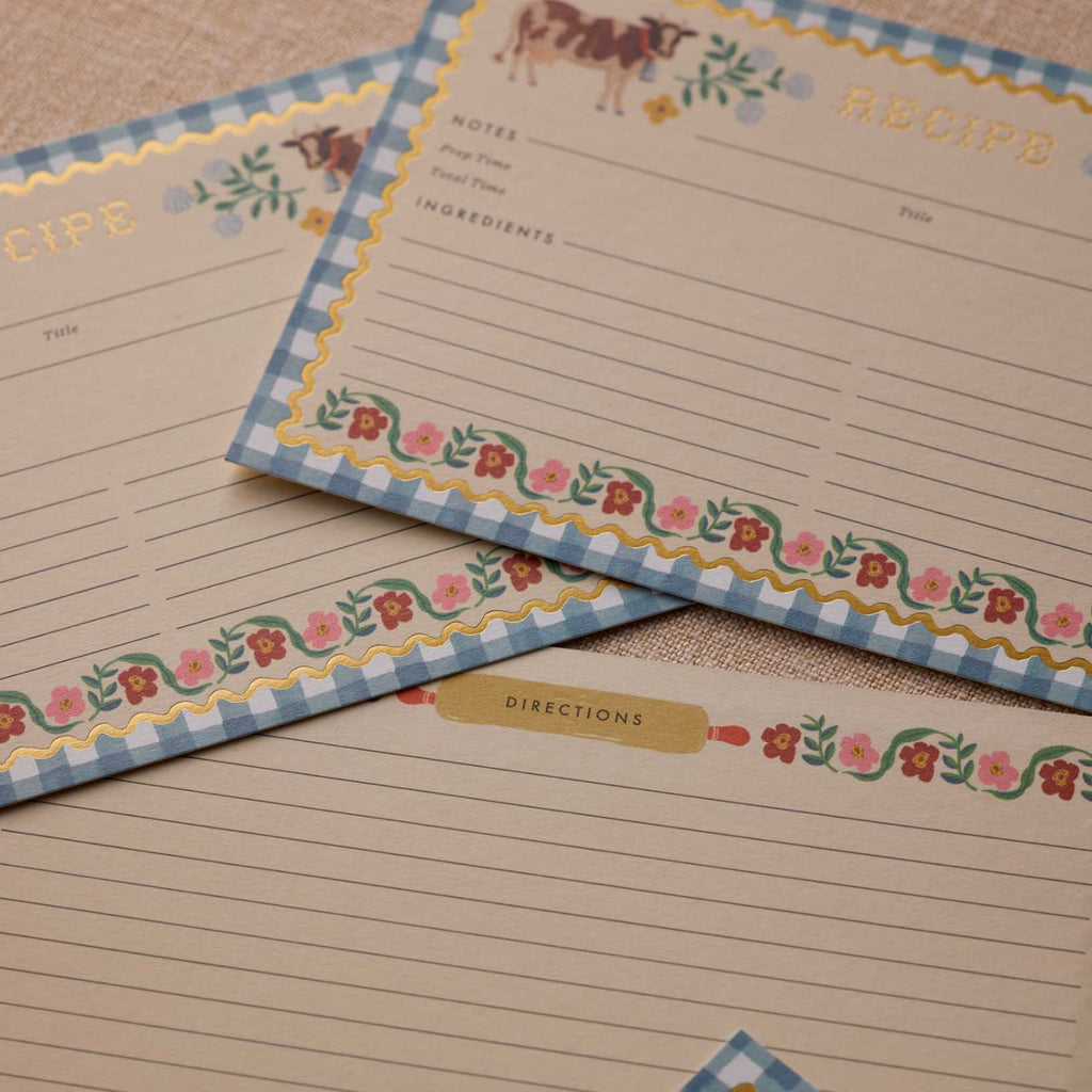 Set of recipe cards with decorative borders on a wooden surface