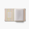An open photo album with a pastel striped cover in pink, yellow, green, and blue, featuring a photo frame insert on the left and white photo sleeves on the right, set against a plain white background.