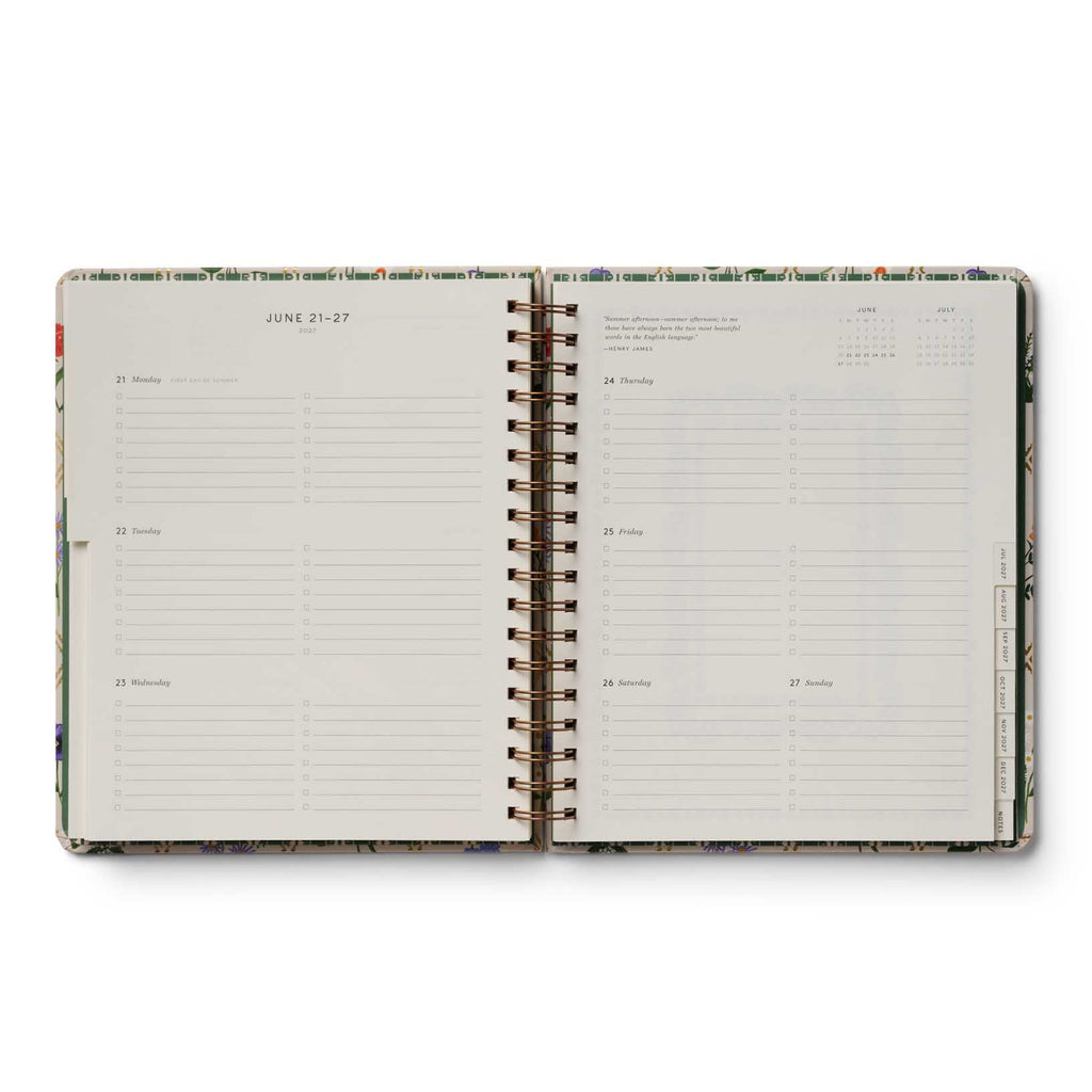 Open spiral-bound planner with floral design on a white background