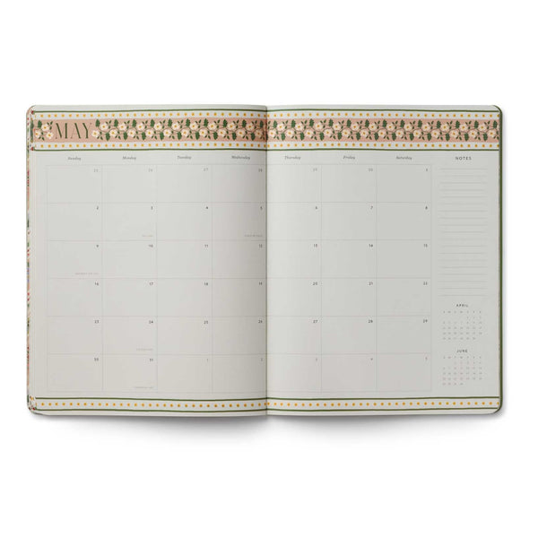 Open planner with decorative cover on a white background