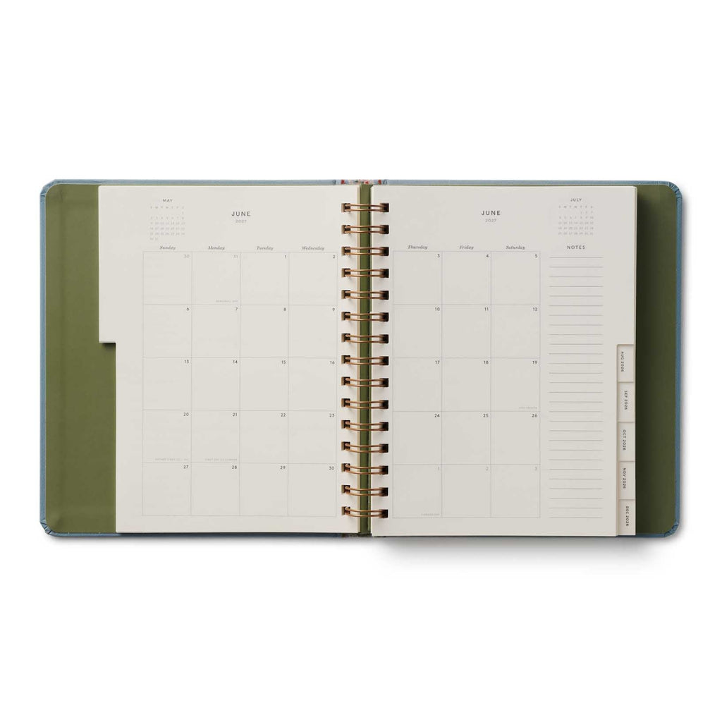 Open planner with green cover and white interior on a white background