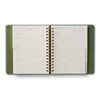 Open planner with green cover on a white background