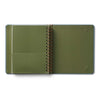 Green notebook with a spiral binding on a white background