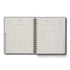Open planner showing a monthly layout on two pages with a decorative border.