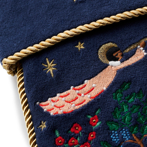 Embroidered design of a person with stars and flowers on a dark blue background