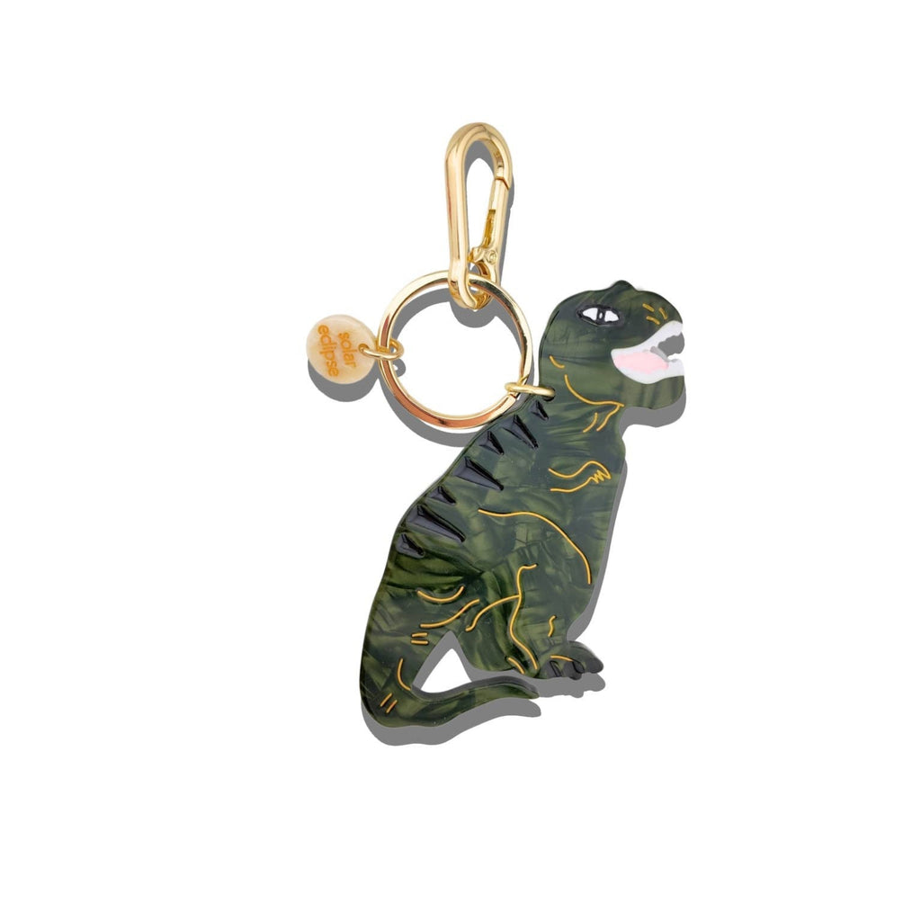 Dinosaur-shaped keychain with gold accents on a white background